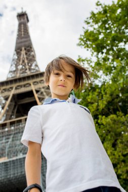 Anaokulu çocuğu, Eyfel kulesinin önünde duruyor, yaz boyunca Paris 'i ziyaret ediyor.