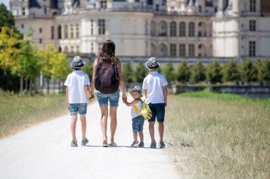 Anne ve çocuklar Fransa 'nın Loire Vadisi' ndeki Chambord Kalesi 'nde bir yaz günü yürüyorlar.