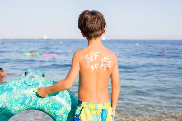 Bambino Ragazzo Preadolescente Con Crema Solare Sulla Schiena Sulla Spiaggia — Foto Stock