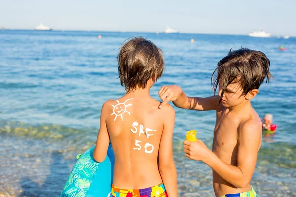 Niño Niño Preadolescente Con Crema Protección Solar Espalda Playa Sosteniendo — Foto de Stock