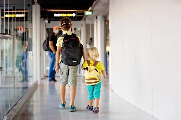蹒跚学步的男孩 戴着口罩的孩子 在机场使用消毒设备 准备飞行 带着一切预防措施的家庭旅行 — 图库照片