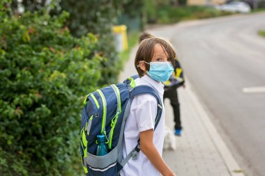 Okul çocukları, çocuklar, yaz tatilinden sonra okula geri dönmek, çocuklar Coronavirus COVID 19 yüzünden maske takarak okula gitmek.