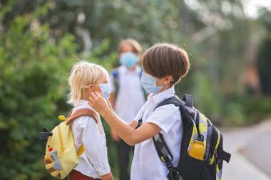 Okul çocukları, çocuklar, yaz tatilinden sonra okula geri dönmek, çocuklar Coronavirus COVID 19 yüzünden maske takarak okula gitmek.