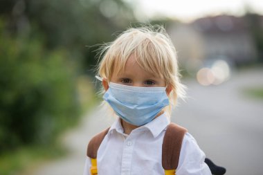 Okul çocukları, çocuklar, yaz tatilinden sonra okula geri dönmek, çocuklar Coronavirus COVID 19 yüzünden maske takarak okula gitmek.