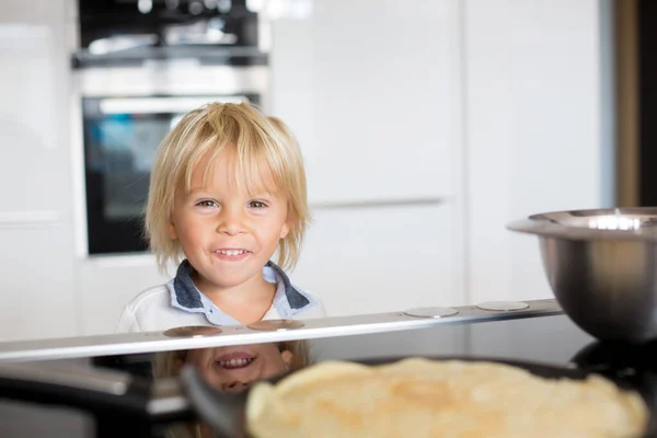 Tatlı Bebek Sarışın Çocuk Mutfakta Krep Yapıp Onları Yiyor — Stok fotoğraf