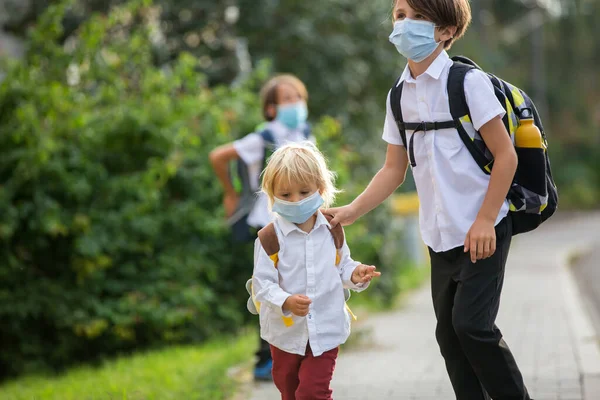 Okul çocukları, çocuklar, yaz tatilinden sonra okula geri dönmek, çocuklar Coronavirus COVID 19 yüzünden maske takarak okula gitmek.