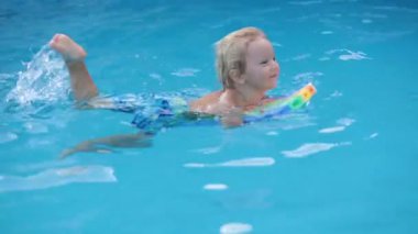 Tatlı sarışın çocuk, küçük çocuk nehirde plastik tekneyle oynuyor, yaz zamanı.