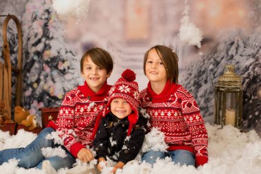 Sevimli çocuk, anaokulu çocuğu, dışarıda karda oynayan, stüdyo fotoğrafı çeken.