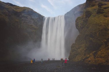 İzlanda 'daki Skogafoss şelalesinin güzel manzarası. Günbatımı bulutlu bir günde, sonbahar zamanı.