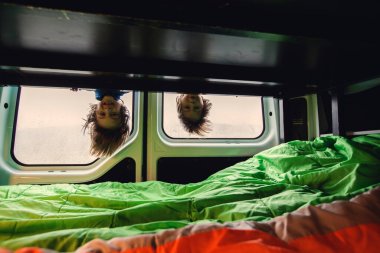 Çocuklar, dışarıda sağanak yağmur yağarken karavanda eğlenmek, oyun oynamak, yaramazlık yapmak, baş aşağı asılı kalmak.