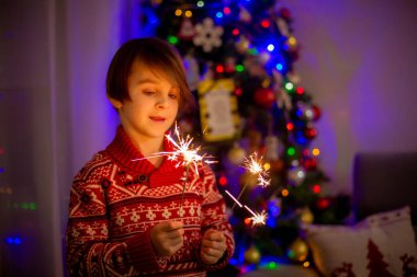 Yılbaşını birlikte kutlayan mutlu çocuk portresi yapın ve evde havai fişek yakın.
