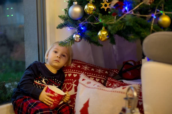 Noel Pijamalı Tatlı Çocuk Noel Ağacının Yanında Oturmuş Süt Içiyor — Stok fotoğraf