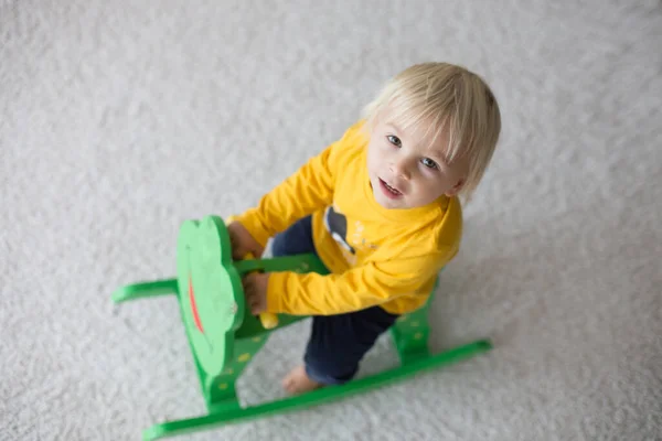 小さなかわいい幼児の男の子 遊ぶとともにロッキングカエルスイングで自宅で子供部屋 — ストック写真