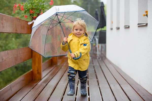 안개낀 길에서 우산을 가지고 빗속에서 귀여운 금발의 — 스톡 사진