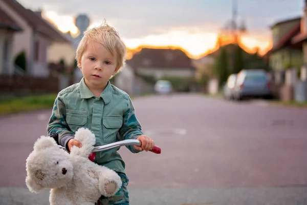 Małe Dziecko Blondyn Jazda Rowerze Trzykołowym Małej Uliczce Zachodzie Słońca — Zdjęcie stockowe