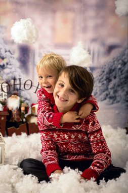 Tatlı çocuklar, erkek kardeşler, güzel çocuklar, dışarıda karda oynuyorlar, Noel konsepti stüdyosu çekimleri.