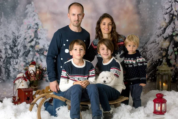 雪の中でクリスマスの写真を撮る幸せな家族 3人の子供と子犬の犬を持つ両親 — ストック写真