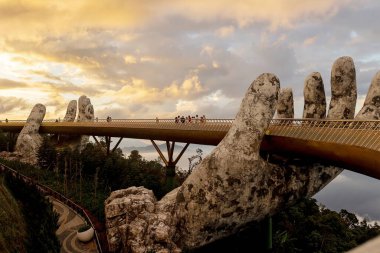 Çocuklu bir aile, Da Nang 'da altın ellerle Golden Köprüsü' nü geziyor, Ba Ha Hills 'e gidiyor, yaz mevsiminde gün batımında Vietnam' a gidiyor.