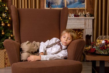 Tatlı sarışın çocuk, tatlı çocuk, Noel 'de Noel oyuncaklarıyla oynayan, Noel için güzel dekore edilmiş ev, ışıklarla dolu rahat bir yer.