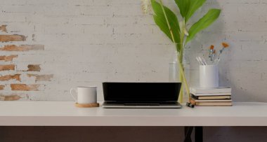 Dizüstü bilgisayar ve ofis malzemeleri ile minimal rahat işyeri