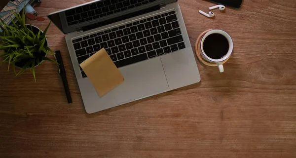 Lugar de trabajo de diseño rústico con computadora portátil y una taza de café — Foto de Stock