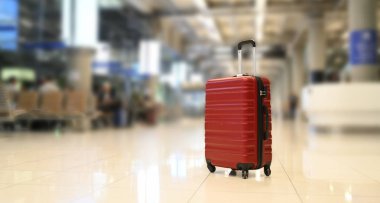 Havaalanı terminalinde kırmızı valiz veya bagaj.