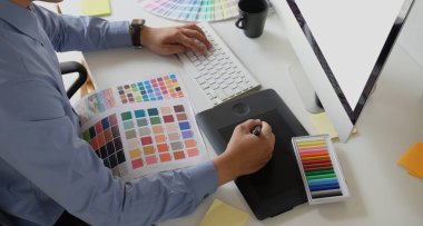 Tablet ve renk swatches çizim ile çalışan grafik tasarımcı