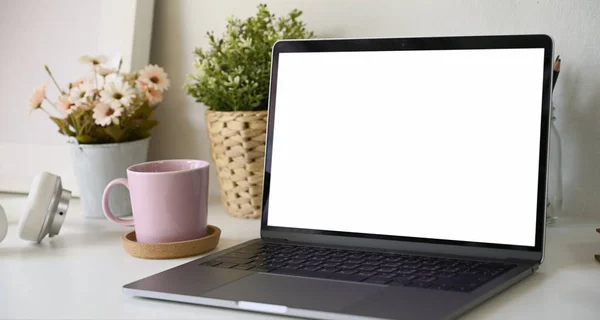 Spazio di lavoro con schermo bianco isolato modellare laptop sulla scrivania — Foto Stock