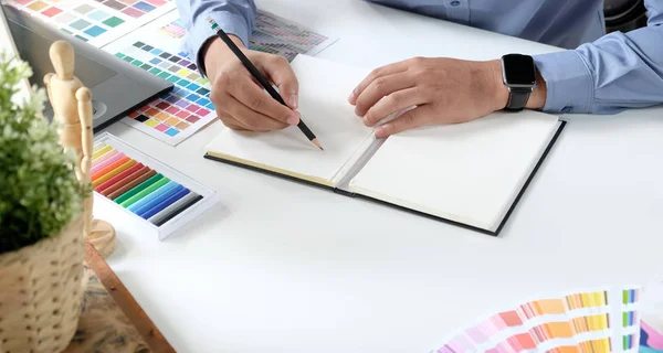 Graphiste travaillant avec des tablettes de dessin et des échantillons de couleurs — Photo