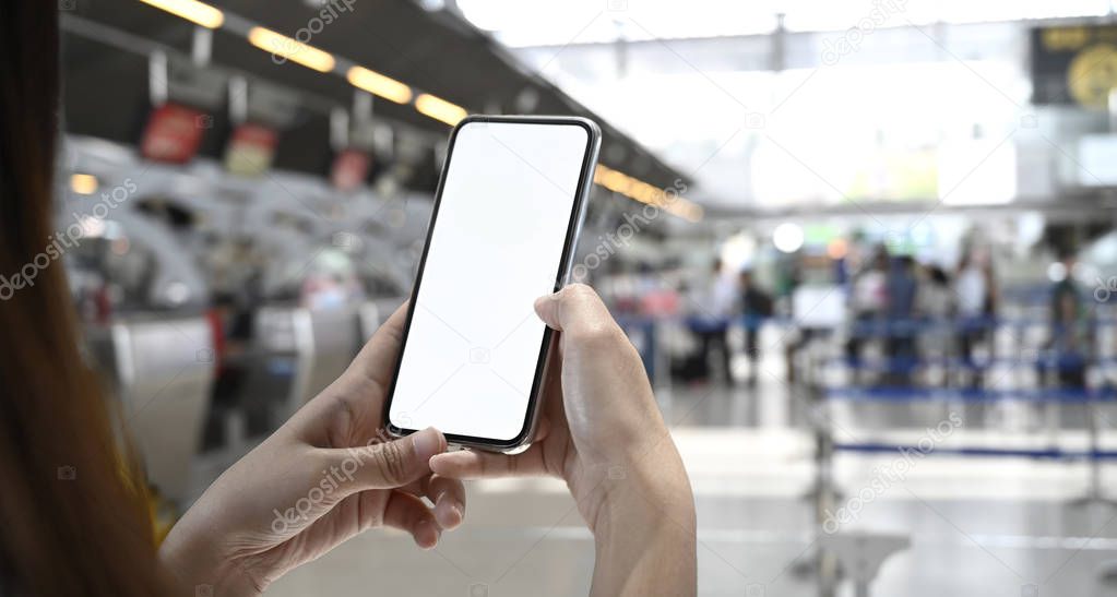 Woman using mobile phone in terminal airport