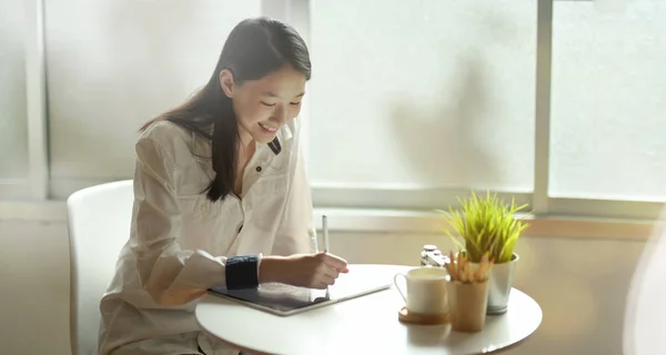 Entzückende junge Freiberuflerin, die am Tablet zeichnet — Stockfoto