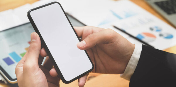 Young businessman and his blank screen smartphone