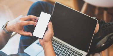 Dizüstü bilgisayar ve akıllı telefon üzerinde çalışan erkek serbest çalışan 