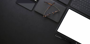Boş ekran tablet ile koyu moda işyeri üst görünümü 