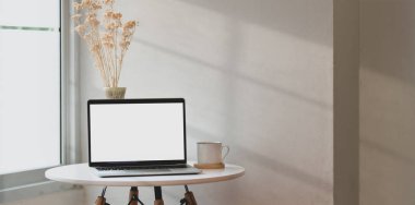 Açık boş ekran dizüstü bilgisayar ve havadar rahat köşesinde dekorasyon ile minimal işyeri 