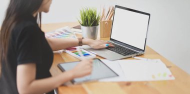 Dizüstü bilgisayarla çalışan genç kadın tasarımcı 