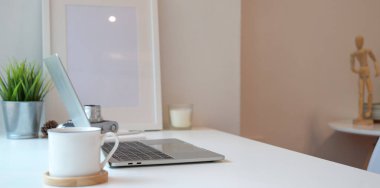 Dizüstü bilgisayar ve bir fincan kahve ile minimal işyeri 