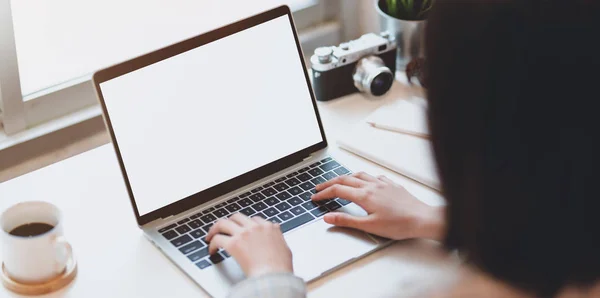 Vista cortada de jovem empresária digitando em lapto de tela em branco — Fotografia de Stock