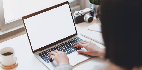 Cropped view of young businesswoman typing on blank screen lapto