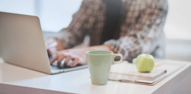 Dizüstü bilgisayarda yazarken projesi üzerinde çalışan tasarımcı