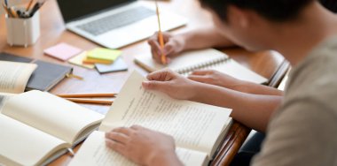 Sınav döneminde kitap okuyan çalışkan üniversiteli adam 