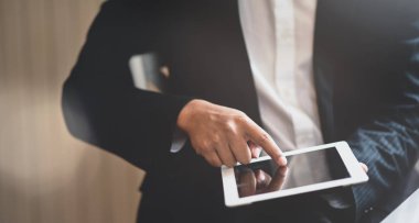 Tablet kullanarak genç işadamının kırpılmış görünümü 
