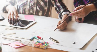 Kadın tasarımcı fikrini iş arkadaşına açıklıyor