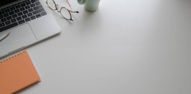 Beyaz masada dizüstü bilgisayar ve ofis malzemeleri ile trendy işyeri 