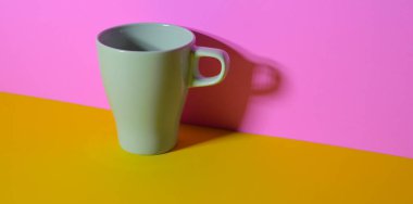 Sarı masa üzerinde renkli bir işyerinde Zeytin yeşili kahve fincanı ve