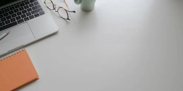 Lugar de trabajo de moda con portátil y suministros de oficina en la mesa blanca —  Fotos de Stock