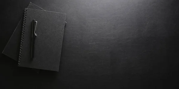 Stijlvolle werkplek met notebook en pen op zwart lederen bureau ba — Stockfoto