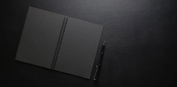 Sötét stílusos munkahely notebook és toll fekete bőr de — Stock Fotó