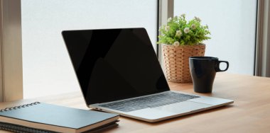 Ahşap masa üzerinde ofis malzemeleri ile açık dizüstü bilgisayar 