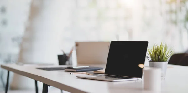 Laptop em branco aberto no local de trabalho moderno com material de escritório e d — Fotografia de Stock